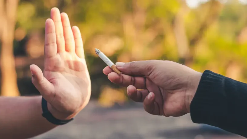 Pessoa se recusando a aceitar um cigarro de outra.