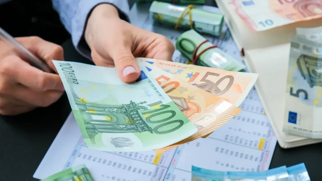 Pessoa fazendo contas com alguns euros na mão