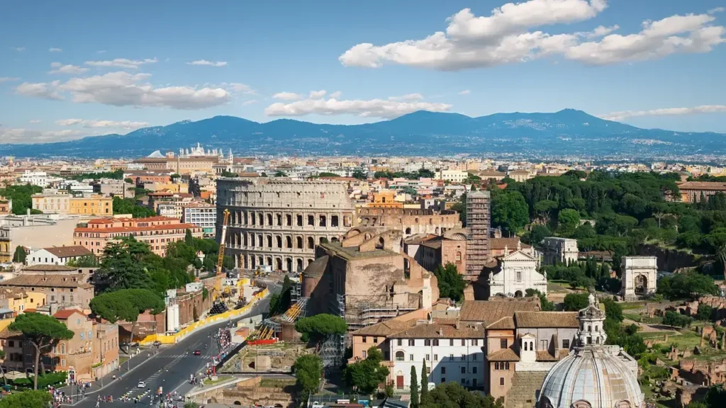 Paisagem da Região de Lazio mostrando Roma e as montanhas ao fundo sob um céu azul.