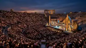 Panorama do 103° Festival de Ópera em Verona 2026 com público e velas acesas na Arena di Verona.